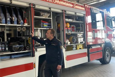 Ein Feuerwehrmann erläutert ein Feuerwehrfahrzeug