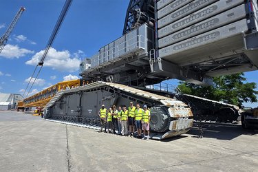 Gruppenfoto vor einem Kran auf dem Werksgelände