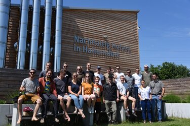 Gruppenfoto mit den Exkursionsteilnehmern vor der Heizzentrale des Solarthermie-Nahwärmenetzes Hallerndorf
