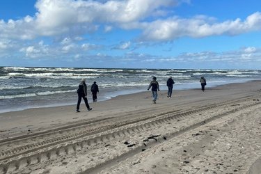 Studierende laufen am Sandstrand