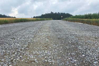 Breiter, gechotterter Zufahrtsweg zur Baustelle