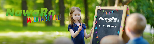 Kinder stehen in der Natur vor einer Tafel mit der Aufschrift: NawaRo - Machen Schule!