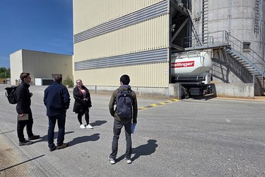 Studierende stehen als Gruppe auf dem Werksgelände
