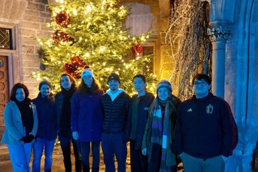 Gruppenfoto mit Austauschstudierende vor einem Weihnachtsbaum
