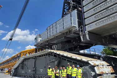 Gruppenfoto vor einem Kran auf dem Werksgelände