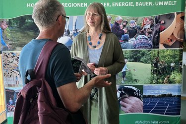 Eine Mitarbeiterin unterhält sich mit einem Besucher