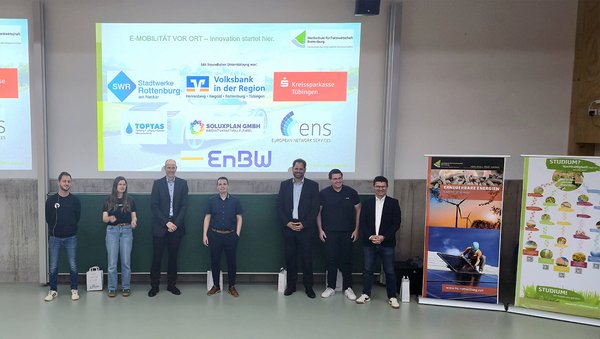 Gruppenfoto mit den Referenten auf der Bühne der Aula 