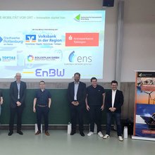 Gruppenfoto mit den Referenten auf der Bühne der Aula 