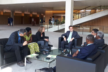 Minister Hauck und die Delegation sitzen in einer Sitzgruppe und unterhalten sich