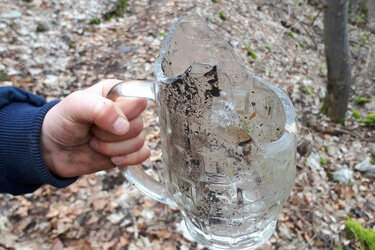 Zerbrochener Bierkrug in der Hand eines Sammlers