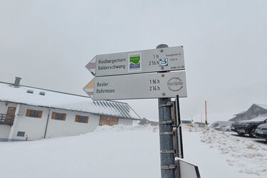 Blick auf ein Wanderwegzeichen mit der Aufschrift der Ziele und Wanderzeit. Die Ziele lauten: Belder, Rohrmoos und Riederberghorn, Balderschwang