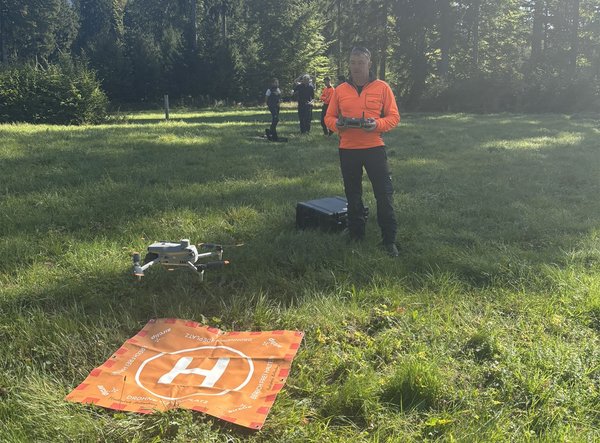 Drohnenpilot beim Landevorgang auf einer Waldwiese