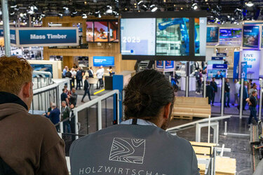 Studierende schauen von oben über die Messehalle hinweg
