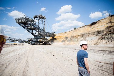 Eine Person mit Helm steht in einer Abraumhalde