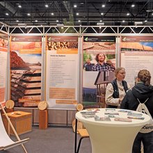 Eine Mitarbeiterin im Gespräch mit Messebesuche am Messestand der Hochschule Rottenburg