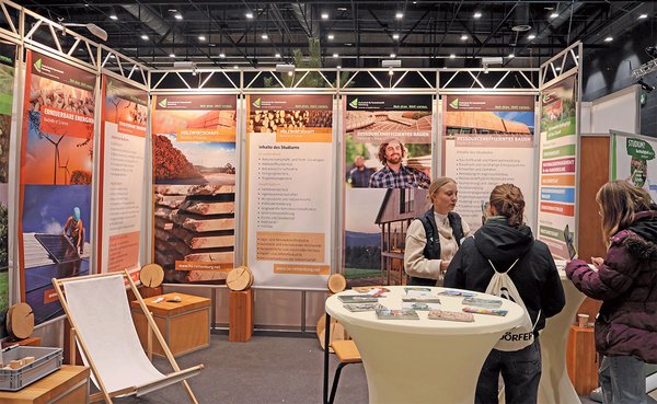 Eine Mitarbeiterin im Gespräch mit Messebesuche am Messestand der Hochschule Rottenburg