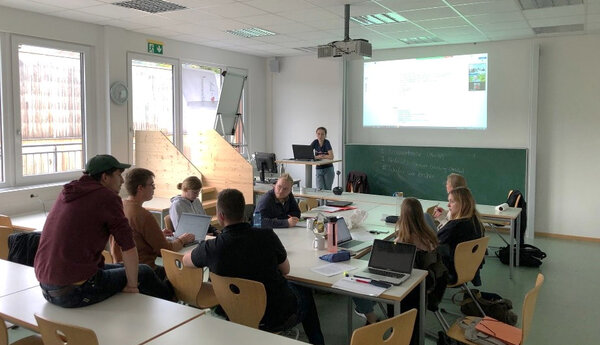 Studierende besprechen sich im Seminarraum