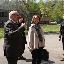 Ministerin Olschowski steht beim Besuch an Hochschule Rottenburg mit einer Delegation vor dem Hochschulgebäude