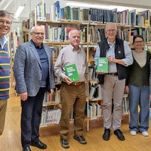 Gruppenfoto in der Bibliothek. Auf dem Foto sind der Rektor, Professoren und Angestellt der Bibliothek gemeinsam mit dem Spender Herr Weik zu sehen.
