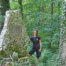 Jana Schumacher steht im Wald neben einem Kleindenkmal