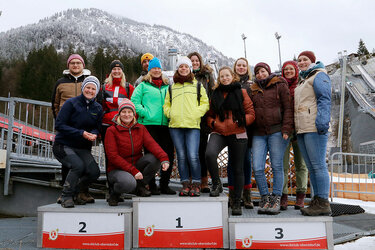 Gruppenfoto mit den Teilnehmern auf dem Siegerpodest vor der Skisprungschanze