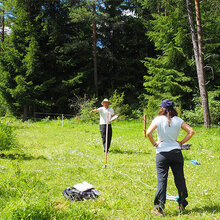 Studierende auf einer Freifläche im Wald mit Fluchtstäben