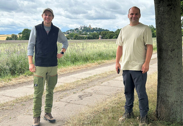 Master-Student Christoph Essiger (li.) und Silvio Ackermann, Forstbetriebsleiter (re.), freuen sich über die gute Entwicklung der Wiederaufforstungsflächen im Forstbetrieb Grünmühle. Im Hintergrund die Augustusburg, eines der bedeutendsten Jagd- und Lustschlösser der sächsischen Kurfürsten, gelegen über dem Zschopautal, rd. 20 km östlich von Chemnitz.