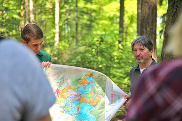 Student und Förster zeigen eine Karte des Lehr- und Forschungswald