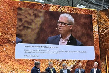 Blick auf eine Bühne mit Teilnehmern einer Podiumsdiskussion.