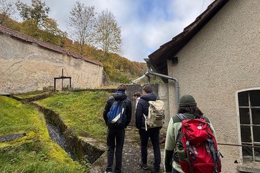 Studiernde schauen sich einen kleinen Wasserlauf an