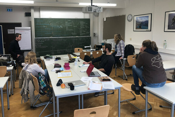 Die Projektgruppe sitzt an einem Tisch zum Brainstorming