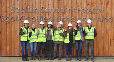 Studierende stehen vor der "Scottish School of Forestry"