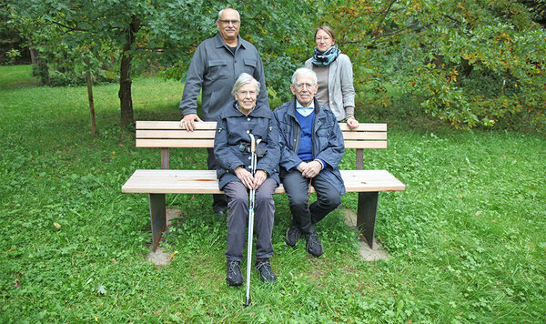 Ursula und Theodor Unz sitzen auf der neuen Bank im Arboretum. Dahinter stehen Prof. Dr. Bastian Kaiser (Rektor HFR) und Prof. Dr. Steffi Heinrichs (Leiterin Arboretum)