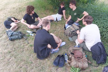 Teilnehmer sitzen im Kreis auf der Wiese und unterhalten sich