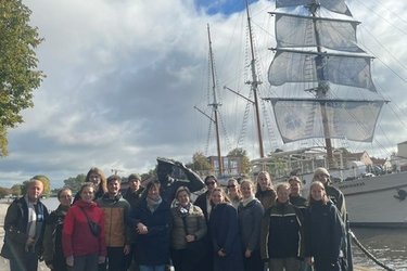 Gruppenfoto mit den Teilnehmern vor einem Segelschiff