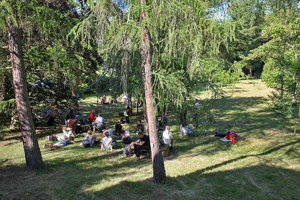 Studierende sitzen im Arboretum und lauschen dem Referenten