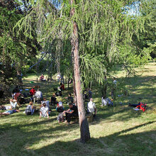 Studierende sitzen im Arboretum und lauschen dem Referenten