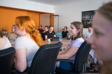 Studierende sitzen an einem Konferenztisch