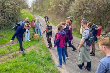 Studierende stehen auf einer Wegkreuzung als Gruppe