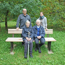 Ursula und Theodor Unz sitzen auf der neuen Bank im Arboretum. Dahinter stehen Prof. Dr. Bastian Kaiser (Rektor HFR) und Prof. Dr. Steffi Heinrichs (Leiterin Arboretum)