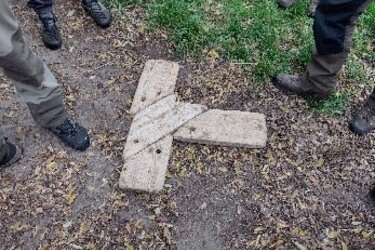 Holzspiel aus unterschiedlichen Holzteielen, die zu einem T zusammengelegt werden müssen. Das gelöste Rätsel liegt auf dem Boden.