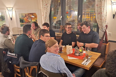 Teilnehmer der Feier sitzen an Tischen in der Gaststätte