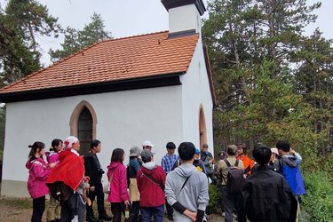 Studierende stehen an einer kleinen Kapelle