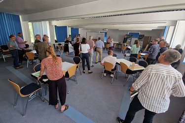 Teilnehmer stehen im Veranstaltungsraum