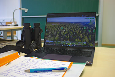 Blick auf ein im Hörsaal stehendes Notebook. Darauf ist das digitale Portal zur Walderkundungen in 3D-VR-360° zu sehen.