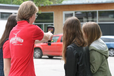 Studentin zeigt interessierten Schülern die Wärmebildkamera