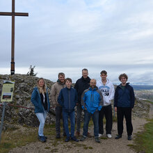 Gruppenfoto der Teilnehmer vor einem Gipfelkreuz