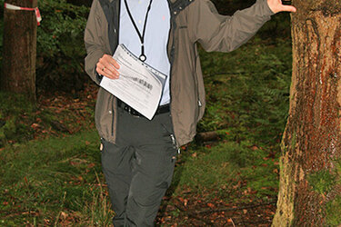 Ein Professor steht im Wald und referiert zum Thema Waldbau