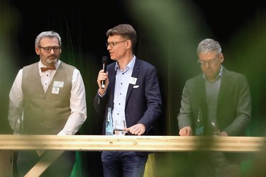 Prof. Burian auf der Bühne mit Mikrofon in der Hand