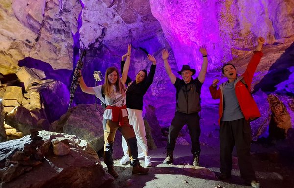 Studierende stehen in der bunt beleuchteten Nebelhöhle